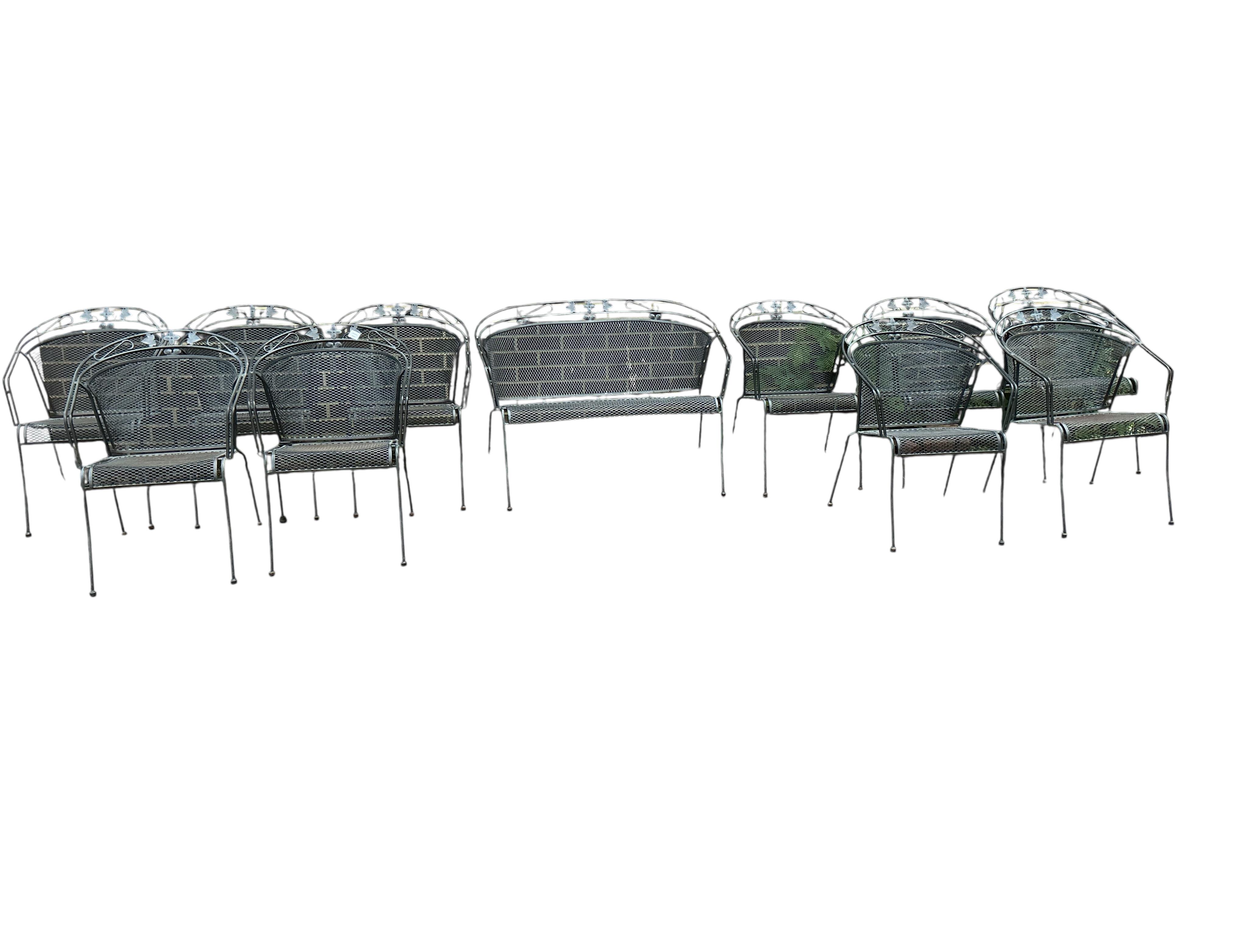 A wrought iron garden bench and ten matching garden chairs